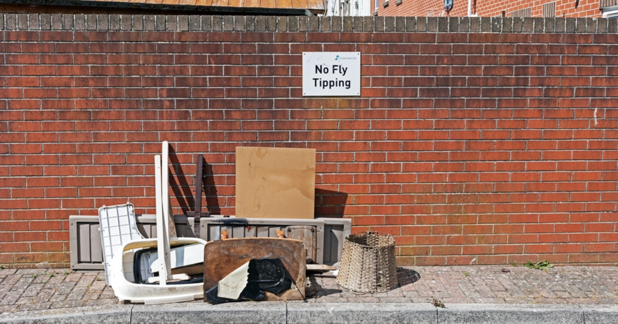 Rubbish dumped beneath a sign reading "No Fly Tipping"