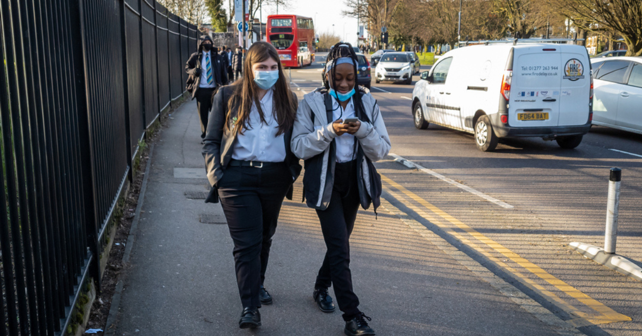 Teens walking on street wearing face masks